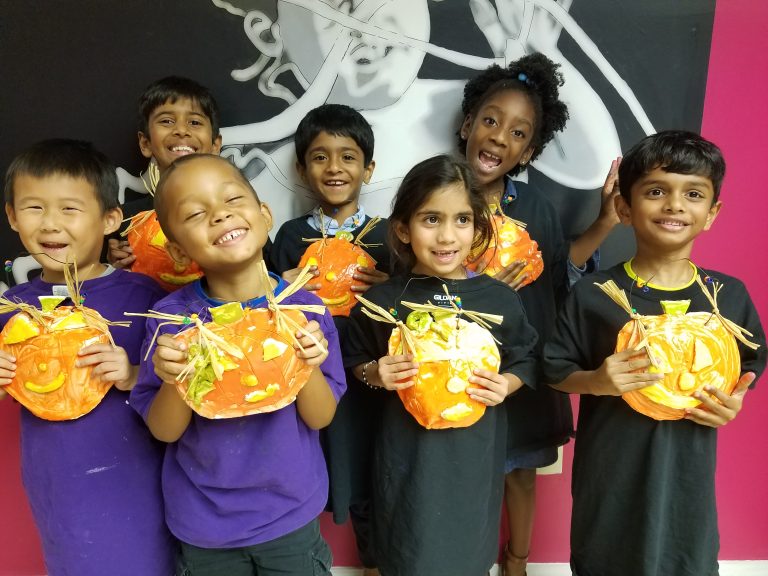 group of children holding pumpkin water color craft