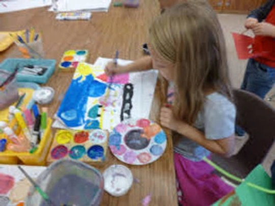 Young girl painting on a paper